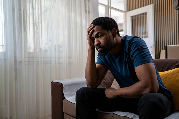 istock Worried man sitting on couch at home 2231166298