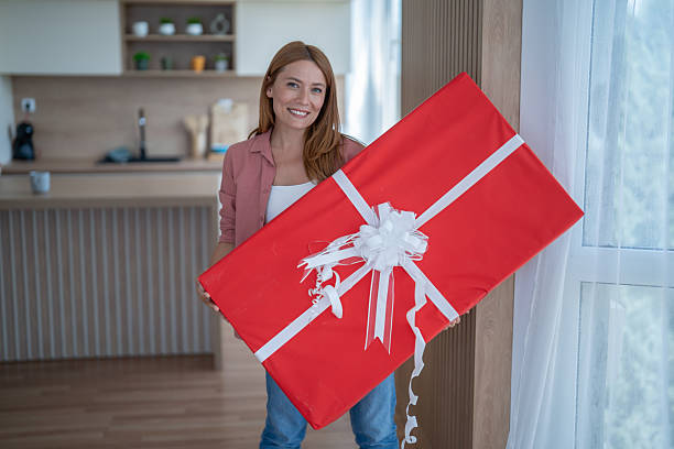 istock Woman holding a large red gift box at home 2231166457
