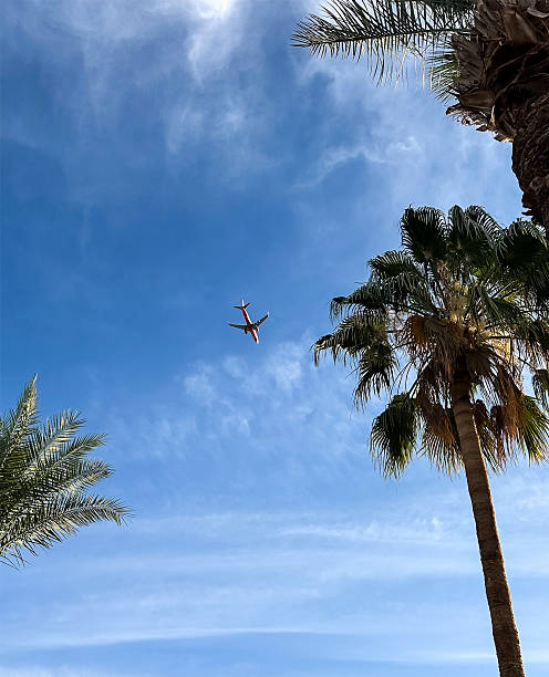istock Airplane in the distance against the blue sky. View from below 2231167162