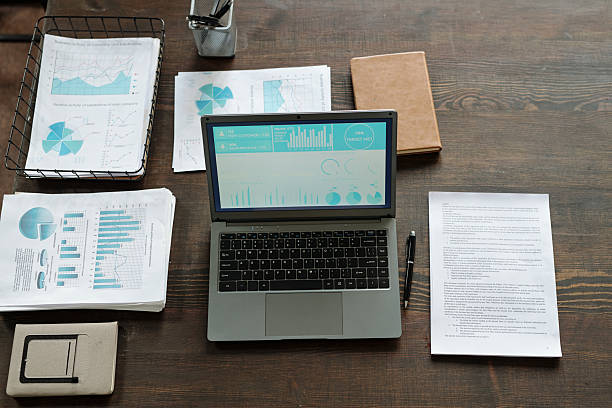 istock Top View of Laptop Displaying Analytics Dashboard Surrounded by Financial Documents 2231181773