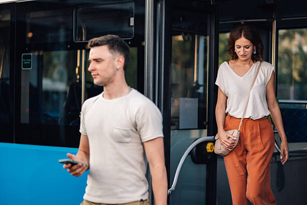 istock Woman exiting bus while man waits with smartphone 2231181852