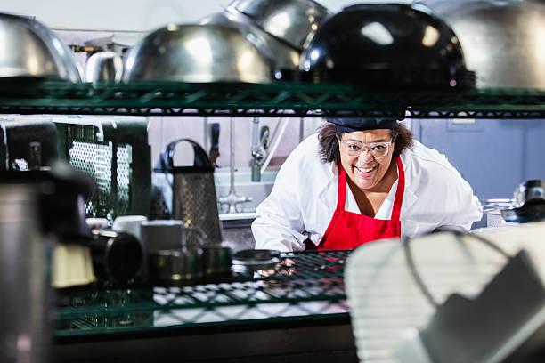 istock Black woman chef in restaurant kitchen smiling at camera 2231182445