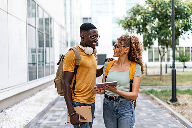 istock Two cheerful university students walking and talking on campus 2231185333