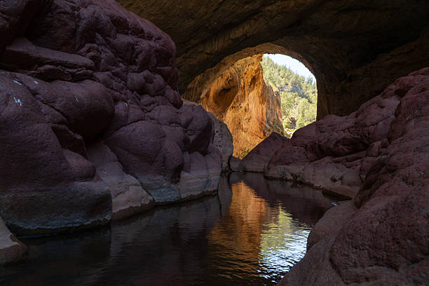 The worlds largest natural travertine bridge. The natural travertine bridge located in Northern Arizona formed over thousands of years, as water from Pine Creek seeped through the surrounding limestone. As the water emerged from springs, it deposited layers of travertine. Over time, the creek eroded a tunnel through the travertine, carving out the natural bridge.