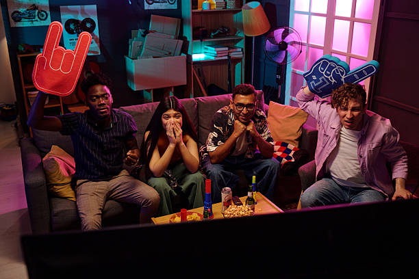 istock Diverse Young Adults Watching Sports Game and Cheering with Excitement 2231193596