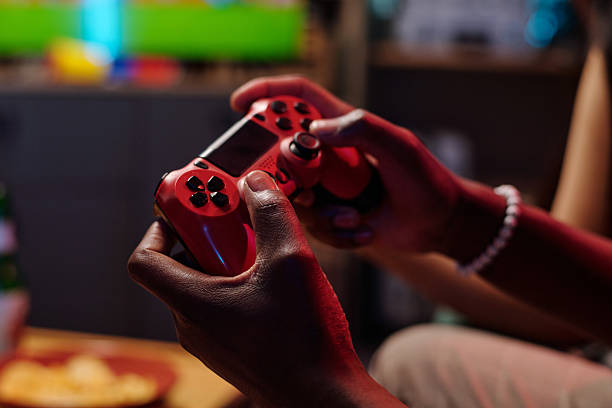 istock Young Adult Black Man Playing Video Game with Wireless Controller Indoors 2231193701