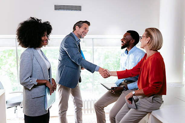 istock Business people shaking hands in modern office: greeting and teamwork 2231193810