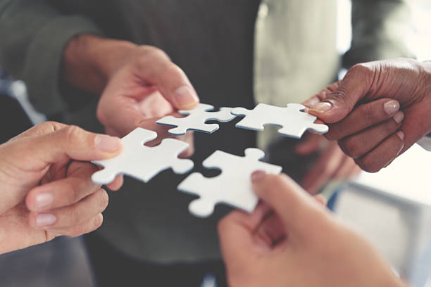 istock Group of business people holding a jigsaw puzzle pieces. Business solution integration merger concept. 2231195952