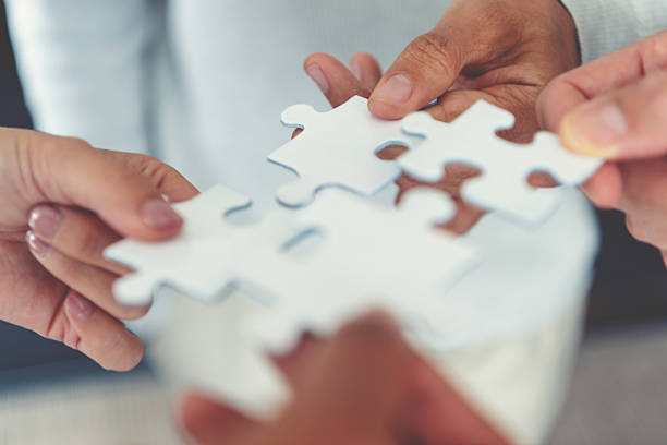 istock Group of business people holding a jigsaw puzzle pieces. Business solution integration merger concept. 2231195963