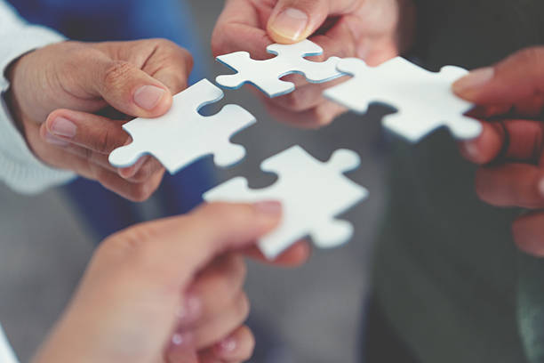 istock Group of business people holding a jigsaw puzzle pieces. Business solution integration merger concept. 2231196054