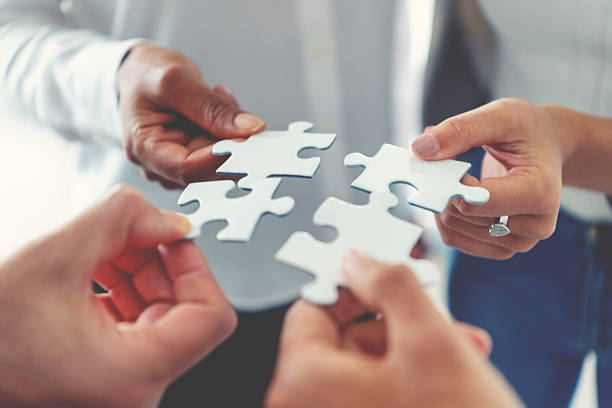 istock Group of business people holding a jigsaw puzzle pieces. Business solution integration merger concept 2231196195