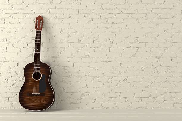 istock Brown classical guitar leaning  on yellow brick wall 2231202531