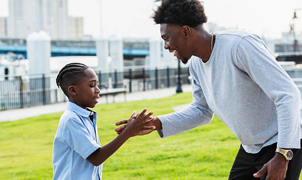 istock Boy in city park with uncle, friendly handshake 2231207309