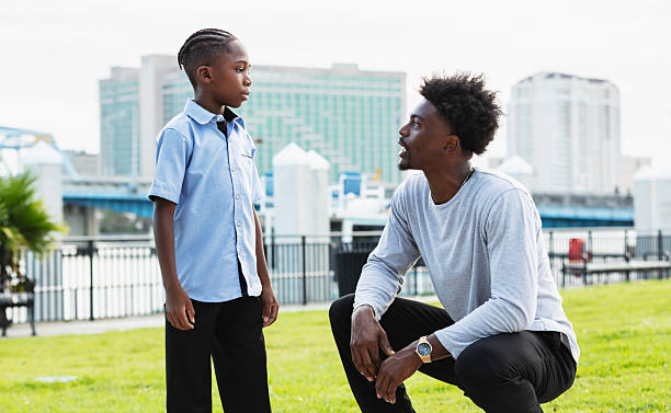 istock Young man talks with nephew, squatting down to eye level 2231207315