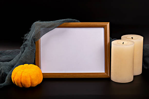 istock Halloween-themed mockup with empty frame, orange pumpkin and candles on dark background 2231210636
