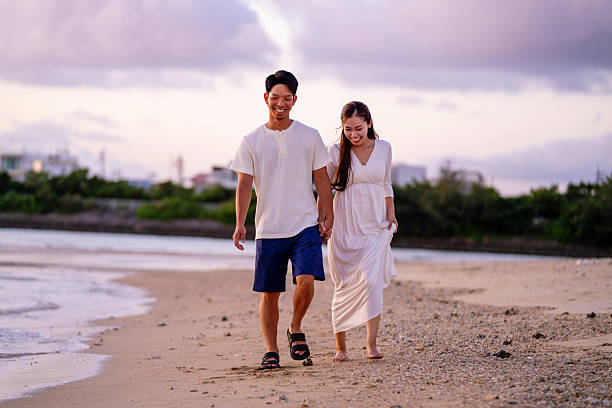 istock Young couple walking on the beach holding hands 2231223258