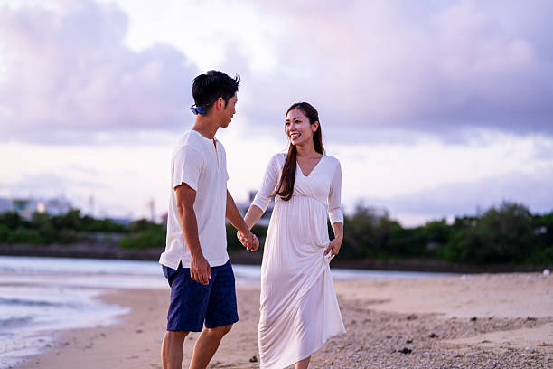 istock Young couple walking on the beach holding hands 2231223261