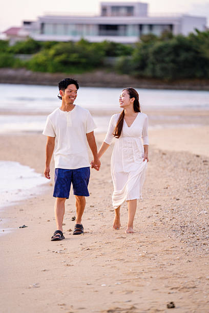 istock Young couple walking on the beach holding hands 2231223267