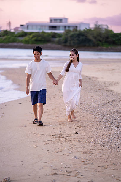 istock Young couple walking on the beach holding hands 2231223283