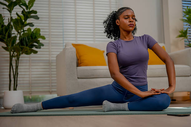 istock Black female engages in indoor exercise, practicing yoga with focus and grace. serene environment enhances her mindfulness and dedication to fitness 2231230676