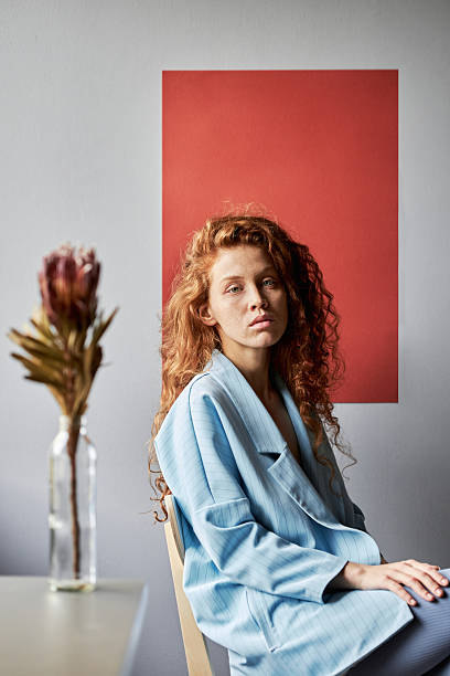 istock Woman with Long Curly Red Hair Looking at Camera 2231233962