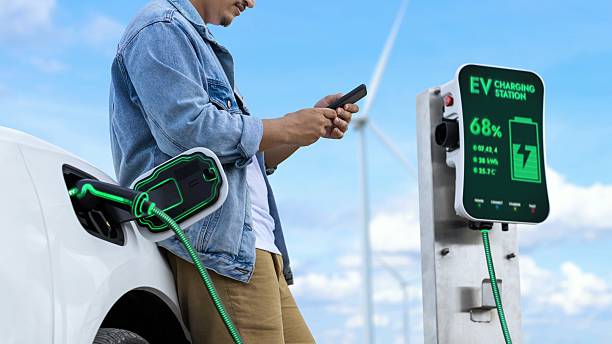 istock Asian man using smartphone while electric car recharging energy. Peruse 2231236891