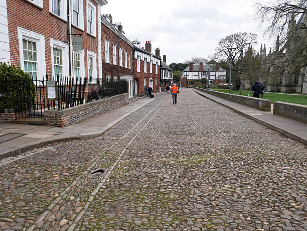 Exeter, Devon, England, United Kingdom - March 6, 2023.Historic listed buildings and cobblestone at Cathedral Close in Exeter, Devon, England, United Kingdom. The street is near St Martin's Church and overlooks  Exeter Cathedral.