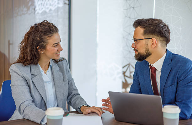istock Businesspeople discussing work in modern office with laptop 2231243161