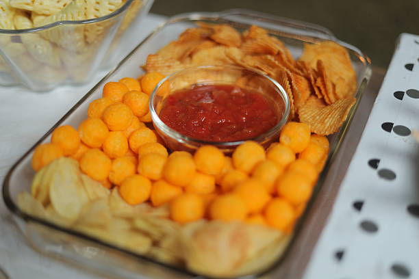Artichoke dip served with potato chips and pita bread on a festive plaid tablecloth