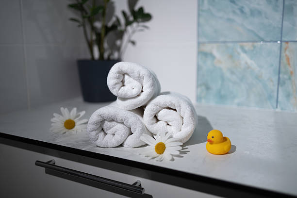 istock Soft Rolled Towels With Flowers and a Rubber Duck on a Bathroom Counter 2231246290
