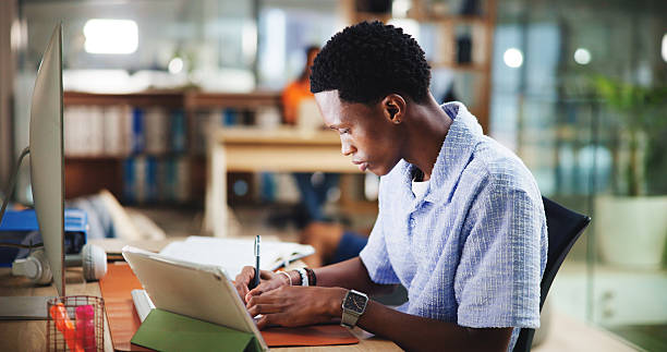istock Writing, college student and black man in library for reading, learning and research project. University, creative or male person with tablet on campus for education, development or studying notes 2231246981