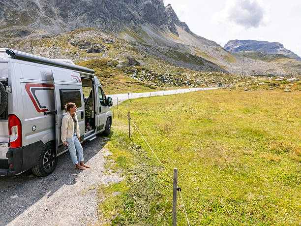 istock Woman Relaxing by Camper Van in Mountain Landscape 2231249277
