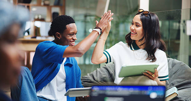 istock University, students or high five with tablet in library for test success, exam results or support. Education, college or people with celebration on campus for assignment goal or scholarship approval 2231252374