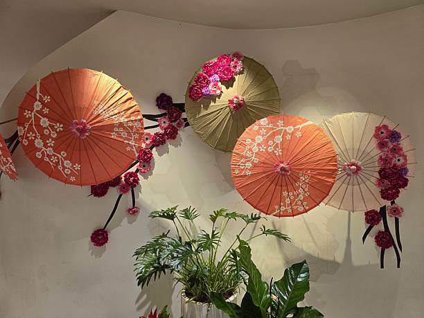 Decorative paper umbrellas with floral accents on a wall backdrop