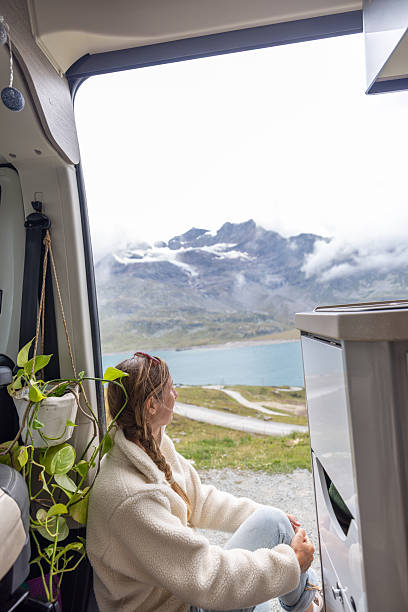 istock Woman Relaxing in Camper Van with Mountain View 2231253516