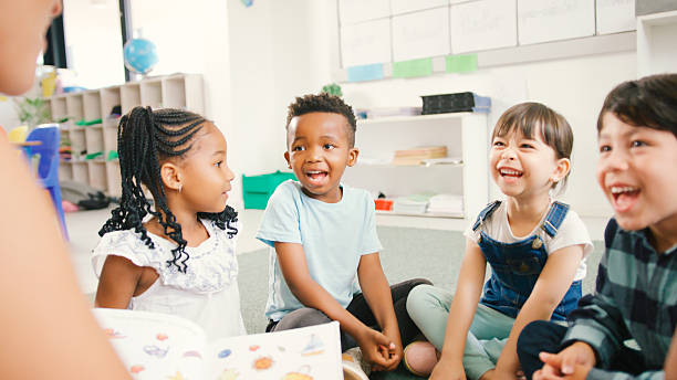 istock Female Teacher Reads And Asks Questions To Multi-Cultural Elementary School Pupils In Class 2231268939