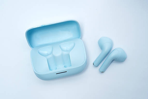 istock Blue wireless earphones with open charging case placed on white background, symbolizing digital lifestyle, portable sound, modern technology, music, and stylish electronic accessory. 2231272290