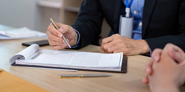 istock Insurance Consultation. Business professional reviewing policy documents with a client. 2231275160