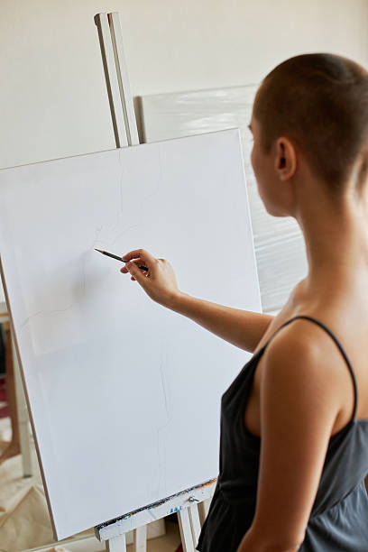 istock Unrecognizable Artist Standing in front of Easel with Canvas Drawing Sketch 2231277549