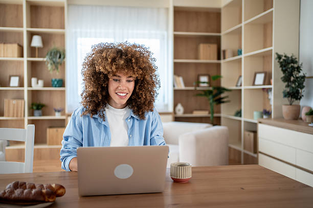istock Young woman working from home on laptop and smiling 2231280814