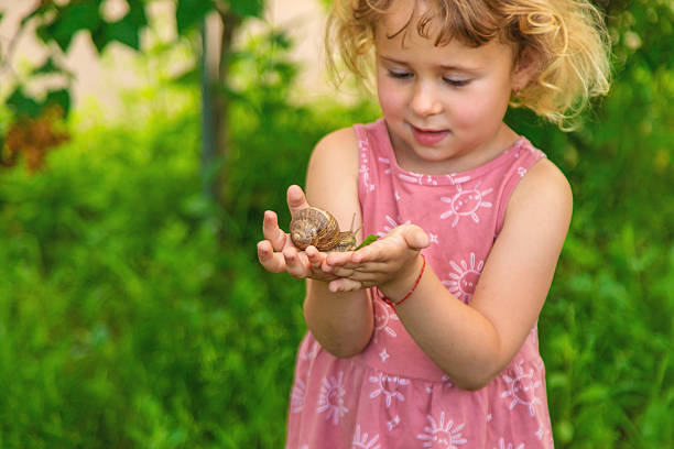 istock Child holding a snail on his hand. Selective focus. 2231281108