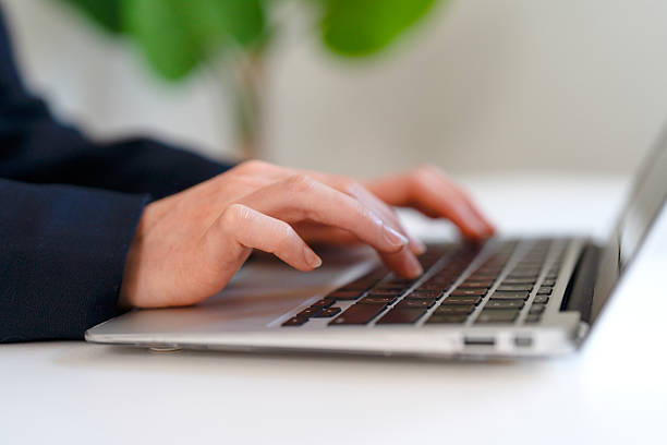 istock Hands typing on a laptop keyboard in a modern workspace with greenery in the background during a productive day 2231281485