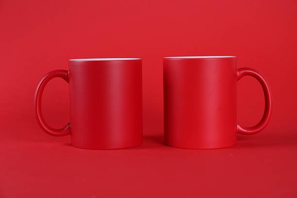istock Two blank mugs on red background. Mockup for design 2231282027
