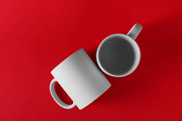istock Two blank white mugs on red background, top view. Mockup for design 2231282255