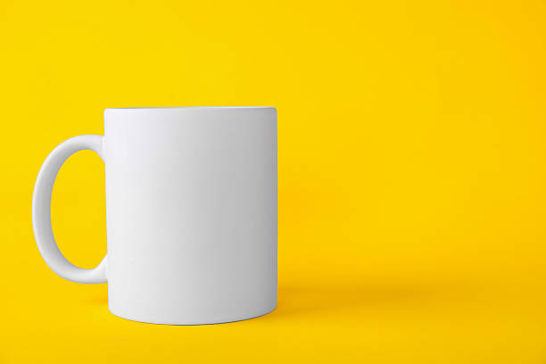 istock One blank white mug on yellow background. Mockup for design 2231282269