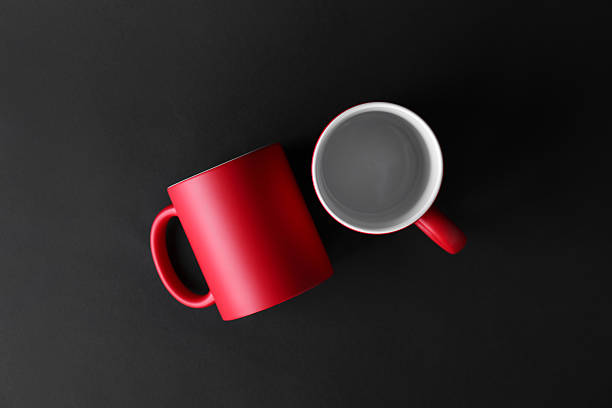 istock Two blank red mugs on black background, top view. Mockup for design 2231282274
