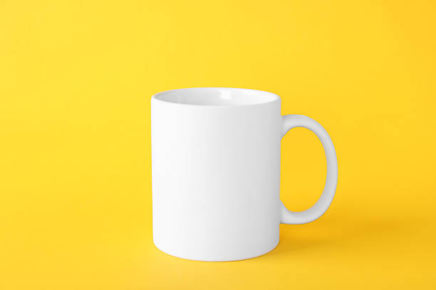 istock One blank white mug on yellow background. Mockup for design 2231282533