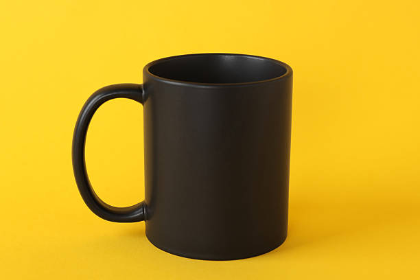 istock One blank black mug on yellow background. Mockup for design 2231282793