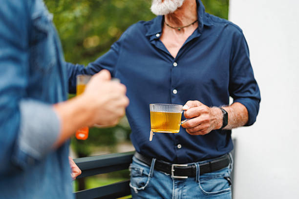 A father and son enjoy a warm moment together while having tea outdoors. The image captures a heartwarming scene of family bonding, showing the importance of connection and shared experiences.