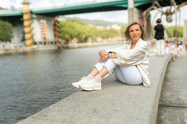 A woman sits on the embankment of the Nervión River